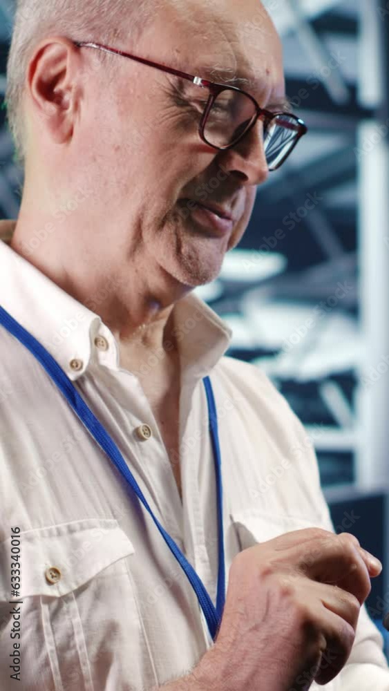 Poster vertical video engineer in high tech data center using tablet to monitor energy efficient servers us