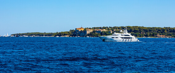 Ile Sainte Marguerite island panorama with Royal Fort castle and yacht sailing on Mediterranean Sea waters offshore Cannes at French Riviera in France