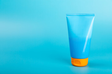 Sunscreen. Jar, cosmetic tube with SPF cream on a bright blue background. The concept of skin care and protection from ultraviolet rays. Photoaging. Sunscreen selection.place for text.copy space.