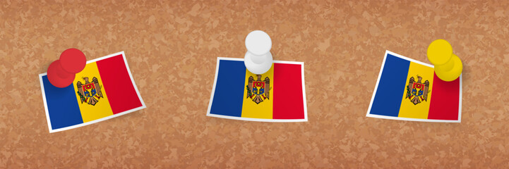Moldova flag pinned in cork board, three versions of Moldova flag.