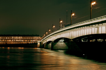 Automobile bridge over the river at night in the city.