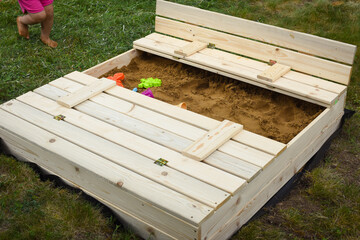 Homemade children´s sandbox, playground with a sand in the garden. Childhood concept. Europe, Czech Republic.