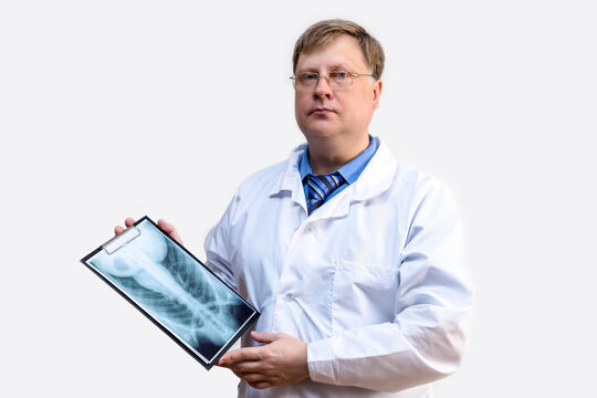 Male doctor in a white coat with an x-ray in his hands, white background.