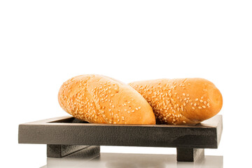 Two delicious fragrant rolls on a black wooden tray, close-up, isolated on white.