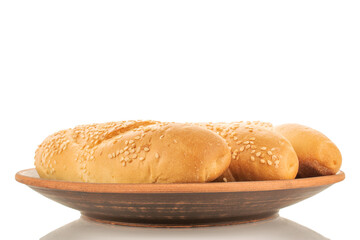 Three fragrant rolls on a clay plate, close-up, isolated on white.