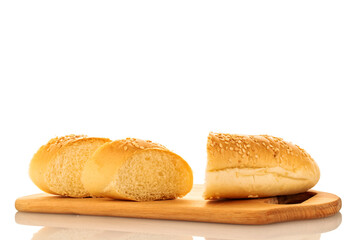 One fragrant bun cut into slices sprinkled with sesame seeds on a wooden board, close-up, isolated on white.