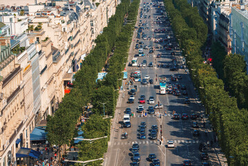 Aerial view of a busy Parisian street with the Eiffel Tower in the background, on a sunny day.