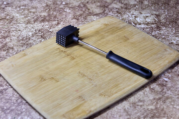 Tenderizing meat with mallet or tenderizer hammer.