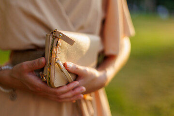stylish girl in an evening dress holds a small bag in her hands. stylish accessories.