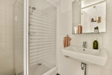 Fototapeta na wymiar a bathroom with a sink, mirror and towel rack on the wall next to it is a glass shower door