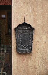 Forged mailbox on the wall of the house