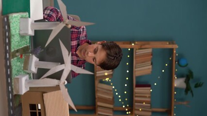 Renewable energy, science, and technology concept. Happy boy working with laptop computer, wind energy and wind turbine models on his project. - Powered by Adobe