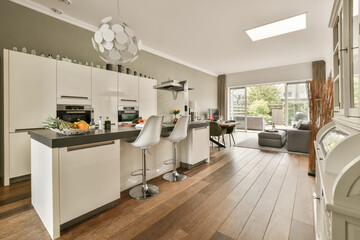 a kitchen and dining area in a house with wood flooring, white cabinets and grey wallpapers on the walls