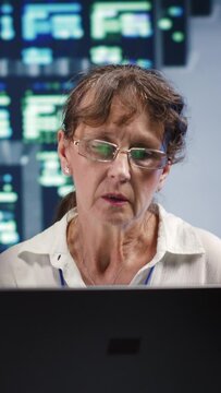 Vertical video Senescent workers looking around innovative supercomputer hub, preparing to start comission on malfunctioning high tech infrastructure in order to ensure optimum operations