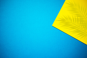 Yellow and blue abstract background with palm leaves shadow