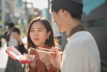 食べ歩きをする笑顔のカップル