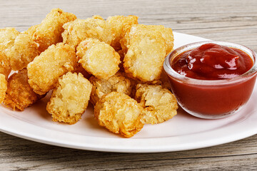 Close up of delicious Tater Tots on a wooden background