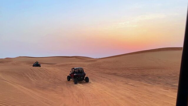 Riding buggies in the desert during sunset