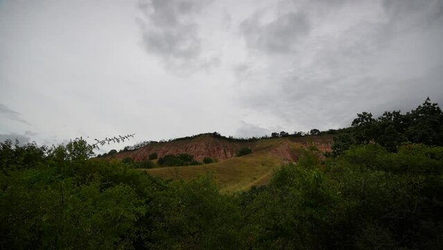 4K time lapse video during a cloudy summer day at Red Ravine (Rapa Rosie in Romanian language) clay soil mountain shapes. Travel to Transylvania, Romania.