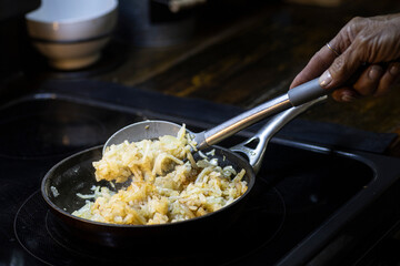 Shredded hash browns cooking in cast iron skillet