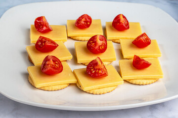 crackers top with cheese and tomatoes,