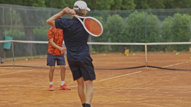 Father and son playing tennis on the court
