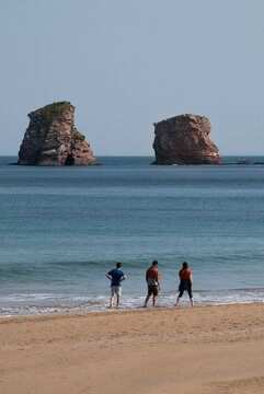 Tres personas paseando por la playa de Hendaya