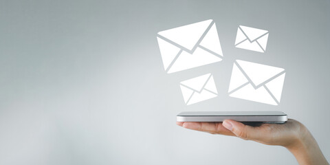 Email, newsletter,notification,communication,digital,business,marketing concept.,Hand holding smartphone with Email marketing icon over white background with copyspace.