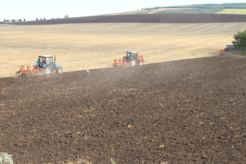 Fototapeta premium A tractor plowing a field