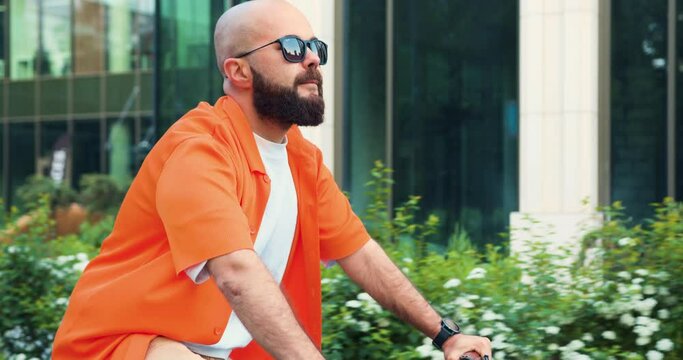 Cyclist man riding fixed gear sport bike in sunny day on a city. Urban city traveler concept. Attractive manager personal assistant cycling commuting to work by eco-friendly vehicle. Modern healthy