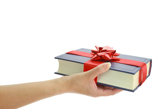 Book gift in a female hand isolated on white transparent background, PNG. 