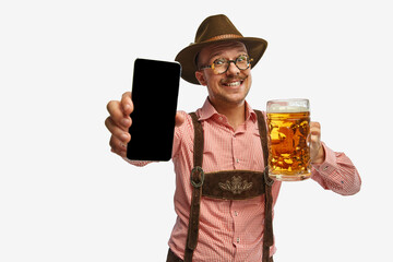 Happy. Young mustache man, waiter in traditional Bavarian ot German outfit show phone with blank...