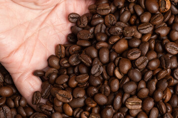 Coffee beans in a hand. Selective focus