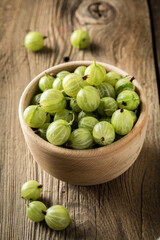 Fresh gooseberry in a wooden bowl.