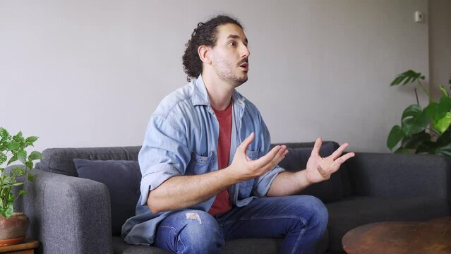 Young male sports fan gets sad and angry watching tv match alone at home