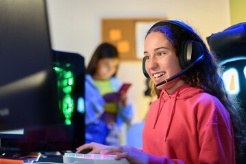 Happy teenage girl in headphones sitting at table and playing games in room © ADDICTIVE STOCK CORE