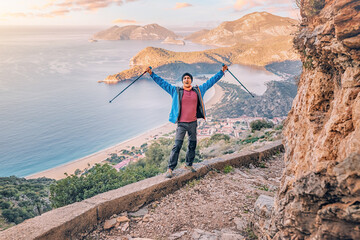 Happy man admiring view of a scenic sunrise over Oludeniz town in Turkey. Lycian Way travel sights...