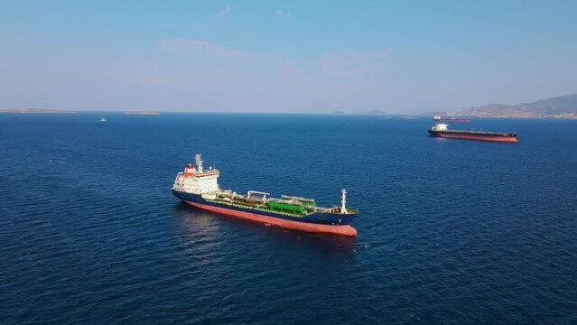 Oil chemical tanker ship anchored in sea industrial port area, aerial wide shot