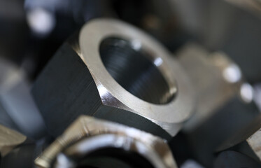 Set of shiny metal screw nuts lying in box closeup