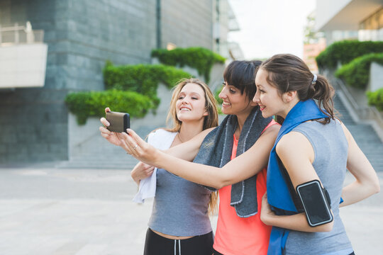 three young sportive women taking selfie