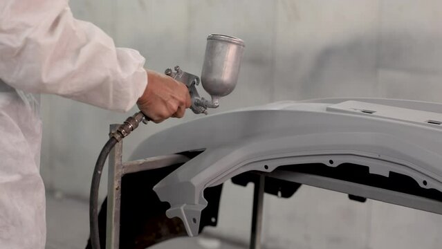 4k, unrecognizable mechanic man in professional vehical garage service shop using spray gun repainting car parts reparing, lifestyle of repair man working with safety uniform, chronic pneumonia cause