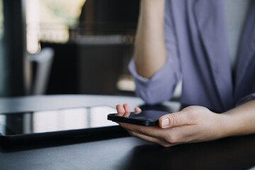 Asian Business woman using calculator and laptop for doing math finance on an office desk, tax, report, accounting, statistics, and analytical research concept