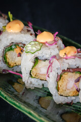 Delicious sushi rolls with sauce on marble tray