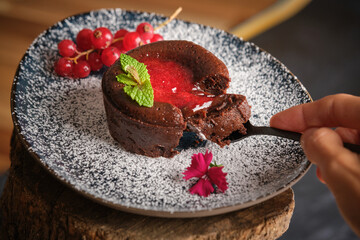 Crop person enjoying chocolate fondant