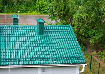 Metal roof on the house. Roof covering, new metal roof.Metal tile in the rain.