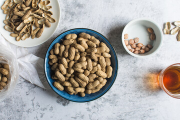 Top view of shelled groundnut in a blue plate, flatlay of shelled peanut in a blue plate on a marble countertop, nigerian roasted groundnut in a bowl