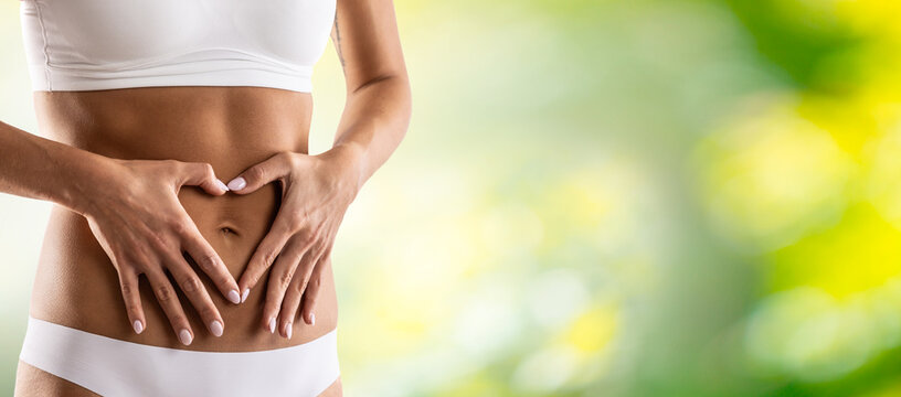 Middle Part Of Female Body With Heart Shape From Hands. A Woman In Underwear Symbolizes A Healthy Lifestyle, A Healthy Stomach, Menstruation Or Pregnancy.