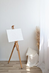 Minimalist aesthetic artist home workspase, easel with abstract plaster design canvas near window...