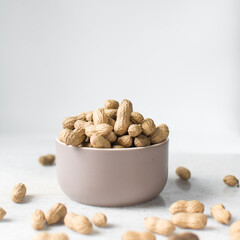 shelled groundnut in a small bowl, top view of shelled peanut in a bowl on a marble countertop, nigerian roasted groundnut in a bowl