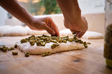 Detail of a baker's hands introducing ingredients into the bread